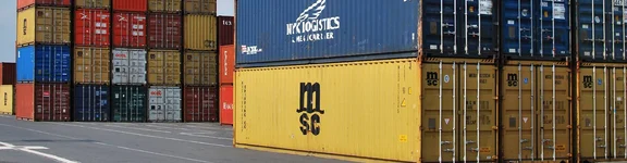 Ein Bild von einem Container Hafen, wo viele bunte Container aufeinander und nebeneinander gestapelt sind